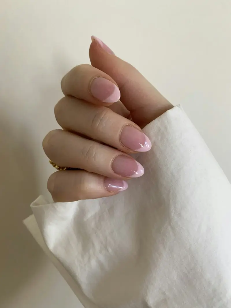 Main aux ongles rose poudré